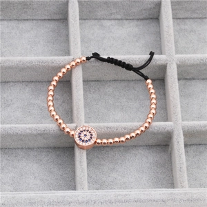 Macro detail of evil eye charm bracelet with micro-paved zircons and rose gold beads