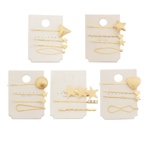 Set of gold metal hair clips in star heart and geometric shapes on display cards