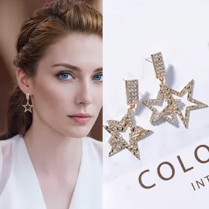 Detail of star-shaped golden drop earrings with high-shine cubic zirconia crystals