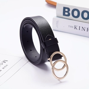 Close-up of black leather belt with golden double ring buckle on a minimalist background