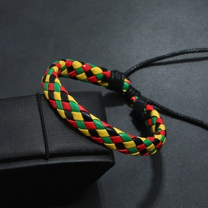 Detail of woven leather bracelet in red green yellow on a black jewelry gift box