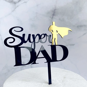 Detail of Super DAD acrylic cake topper with superhero silhouette on white cake