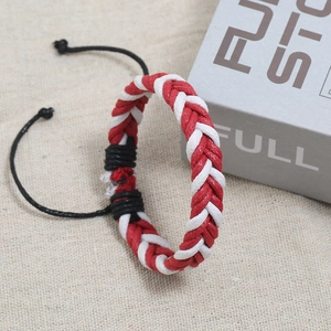 Detail of handmade braided rope bracelet with red and white patterns and adjustable cord