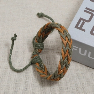 Close-up of handmade woven rope bracelet in olive green and orange brown cotton fiber