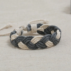 Close-up of hand-woven cotton cord bracelet featuring twisted grey and beige knot textures