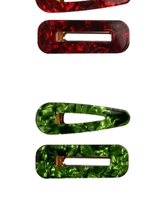 Close-up of 4-piece acetate hair clip set in marble red and green with gold metal base