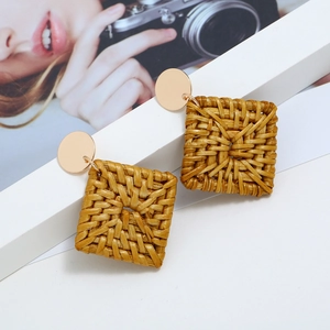 Texture détaillée de boucles d'oreilles géométriques en rotin avec clous dorés