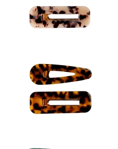Close-up of tortoiseshell acetate hair clips with premium glossy texture and metal clips