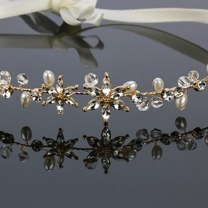 Close-up of golden metal wire headband featuring clear crystals and white faux pearls