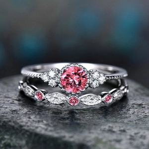 Macro shot of two-piece sterling silver ring set with round pink stone and diamond halo