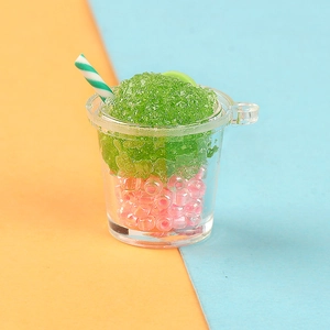 Macro detail of miniature resin smoothie cup charm with pink pearls and green ice