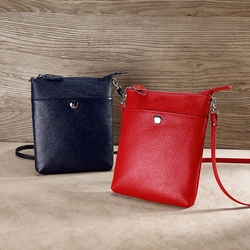 Detail of genuine leather coin pouches in red and blue with litchi texture and silver snap button