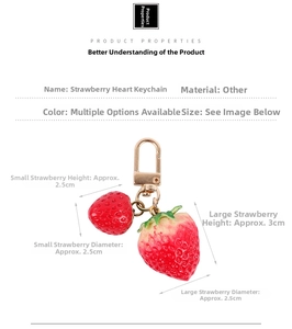 Close-up of strawberry heart keychain with resin berries and golden lobster clasp detail