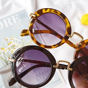 Detail view of round leopard and black kids' sunglasses with UV 400 protection labels