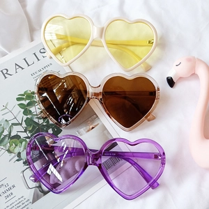 Detailed flat lay of heart shaped sunglasses in yellow, brown, and purple frames