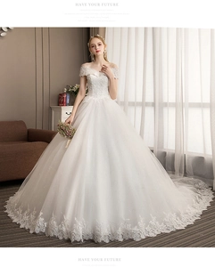 Detailed embroidery and delicate lace appliques on white off-the-shoulder wedding gown
