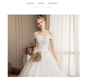 Detail of off-shoulder lace bodice with delicate bead embroidery on a white wedding dress