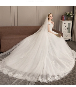 Detail view of the long lace wedding dress train and matching luxury veil