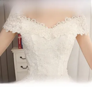 Detail of off-shoulder lace wedding dress with delicate pearl embroidery and floral patterns