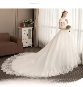 Detail of off-the-shoulder lace embroidery and long train on elegant white bridal gown
