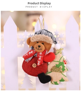 Detail of Christmas bear plush with a burlap tree ornament on a warm festive background