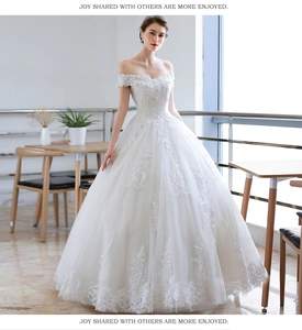 Detail of off-the-shoulder wedding dress featuring intricate floral lace embroidery