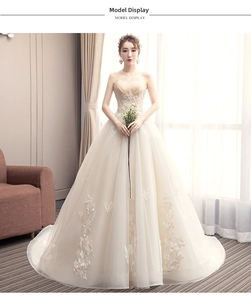 Detailed view of champagne tube top wedding dress with 3D floral and sequin embroidery