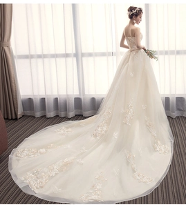 Detail of elegant back corset lacing and luxury long lace train for bridal gown