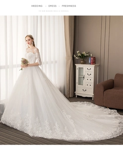 Detailed side view of elegant long sleeve white wedding dress with long lace train