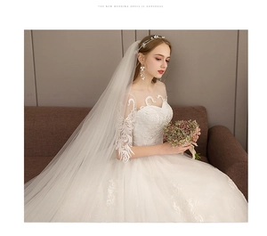 Detail of elegant white wedding dress with sheer lace neckline and floral embroidery