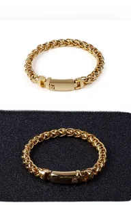 Detail of gold-colored woven wheat chain bracelet with a polished wide clasp closure