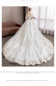 Detail of off-the-shoulder lace bridal gown featuring intricate embroidery and a long train