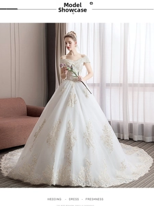 Detailed embroidery and lace patterns on a luxury white off-shoulder bridal ball gown