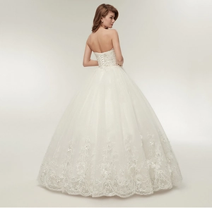 Detailed view of the corset lace-up back and intricate lace floral embroidery on white gown