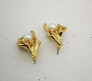 Detail of 18K gold-plated brass flower earrings with a centered white pearl inlay
