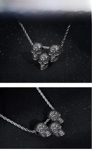 Macro detail of three vintage steel skull pendants with intricate engraved textures