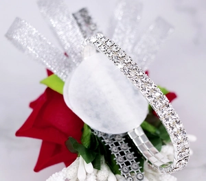Close-up of a red rose wrist corsage with sparkling silver crystal rhinestone strap
