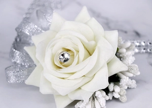 Close-up of cream faux rose wrist corsage with crystal center and silver accents