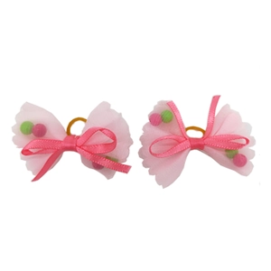 Close-up of pink translucent mesh and satin pet hair bows with small colorful beads