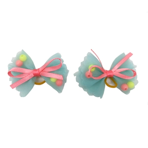 Detail of blue mesh and pink ribbon pet hair bows with colorful beads and yellow bands