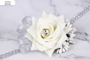 Macro shot of ivory white faux rose wrist corsage with crystal rhinestones and silver ribbons