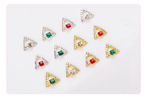 Detailed macro view of 3D triangle nail art charms with square rhinestones and gold frames