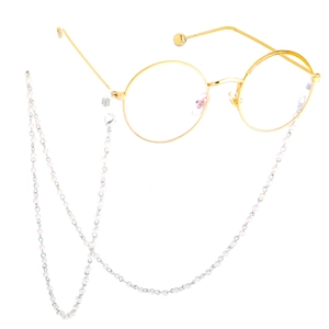 Detailed view of golden round metal glasses with elegant white faux pearl lanyard strap