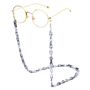 Detail of marble pattern acrylic eyewear chain attached to vintage gold round glasses
