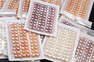 Multiple sets of natural freshwater button pearls in white pink and purple on display cards
