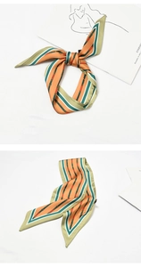 Detail showing orange and green striped silk scarf tied in a bow and hanging naturally