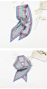Flat lay of blue silk scarf with pink polka dots and stripes on white background