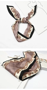 Detailed view of silk-like scarf with classic chain patterns in brown and beige tones