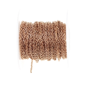 Macro shot of rose gold flat oval chain links on a spool for DIY jewelry crafts