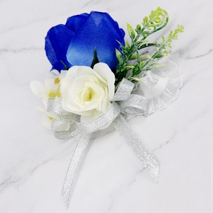 Detail van een koningsblauwe en crème zijden roos bruiloft corsage met zilveren lint
